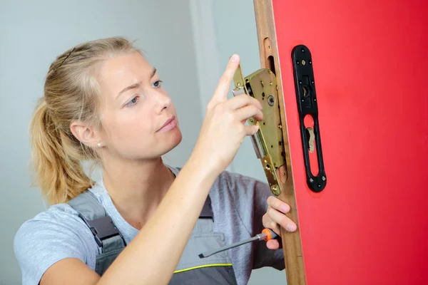 Lady fitting lock in door — Stock Photo, Image