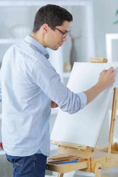 Porträtt av en ung manlig konstnär på jobbet — Stockfoto