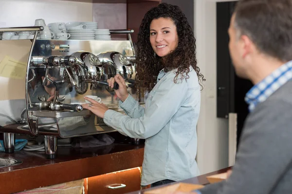 Kobieta za pomocą ekspres do kawy do obsługi klienta — Zdjęcie stockowe