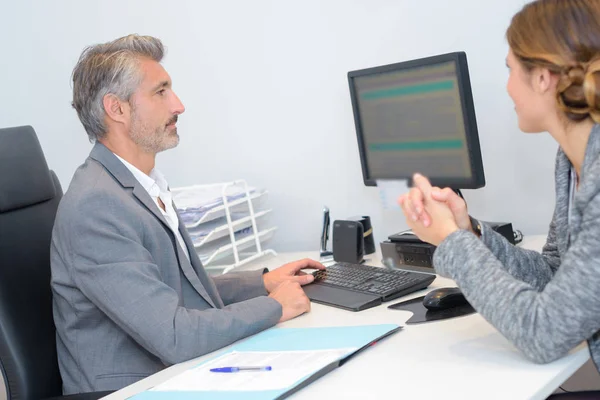 Man en vrouw in de vergadering computerscherm kijken — Stockfoto