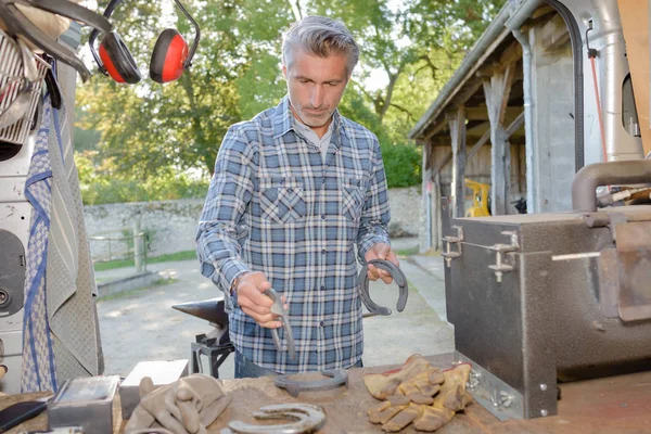 Farrier sosteniendo herradura y herrero — Foto de Stock