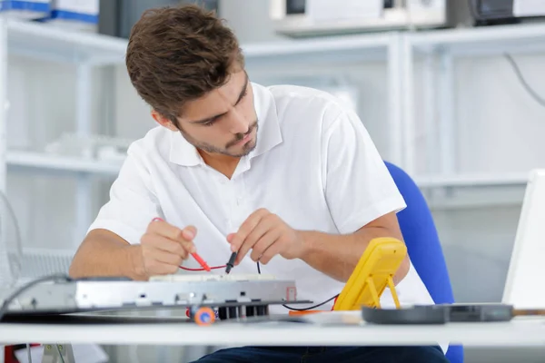 Handsome electrician testing induction hobs — Stock Photo, Image