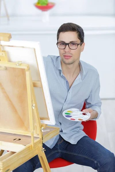 年轻男子艺术家颜料在画布上用油画颜料 — 图库照片