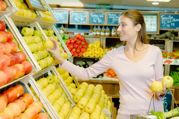 Jovem mulher escolhendo frutas — Fotografia de Stock