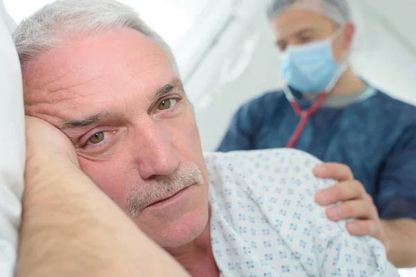 Senior patiënt op zijn kant in ziekenhuisbed — Stockfoto