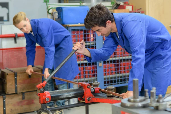 Trabajadores industriales que cortan una barra de acero — Foto de Stock