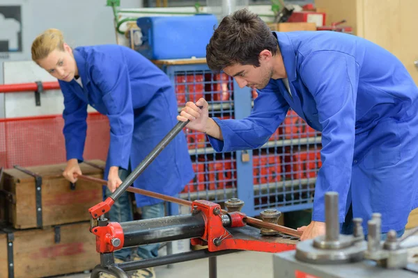 Travailleurs industriels coupant une tige d'acier — Photo