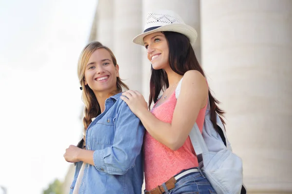 Glückliche Freundinnen spazieren im Urlaub durch die Stadt — Stockfoto