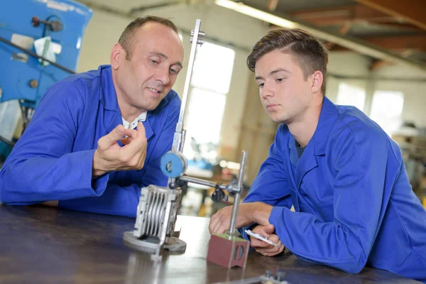 Twee ingenieurs kijken naar metalen apparaat — Stockfoto