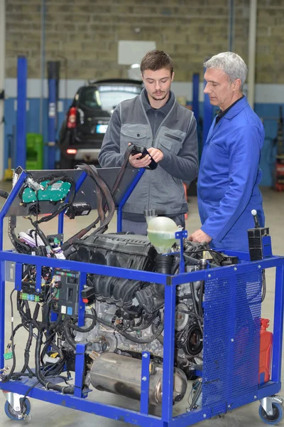 Aprendiz mecânico trabalhando no bloco de motor com professor sênior — Fotografia de Stock