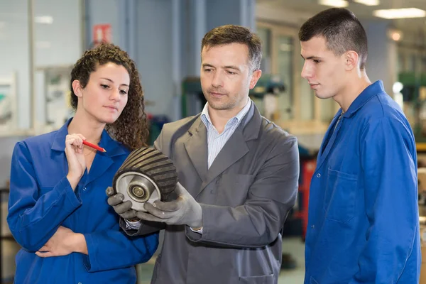 People looking at mechanical part — Stock Photo, Image