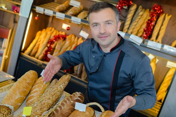 Bäckereifachverkäufer ist stolz auf seine Brotproduktion — Stockfoto