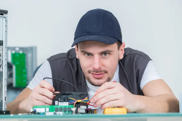Инженер-электронщик, ремонтирующий электронные устройства на сломанном компьютере — стоковое фото