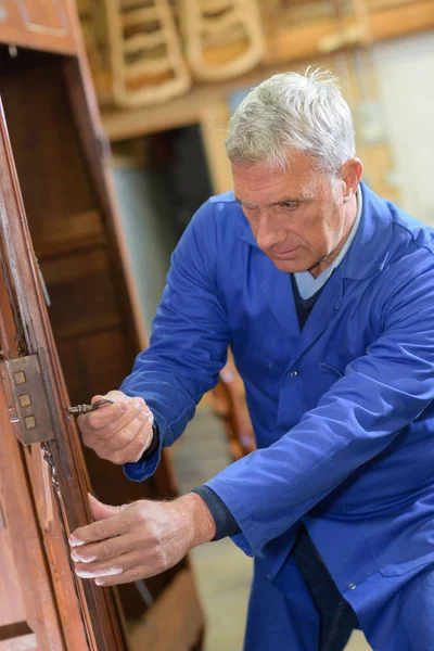 Carpinteiro sênior restaurar móveis antigos — Fotografia de Stock