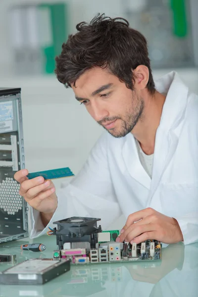 Joven reparador de computadoras mirando el componente — Foto de Stock