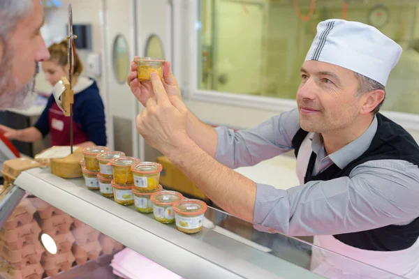 Shop assistant recommending jar to customer — Stock Photo, Image