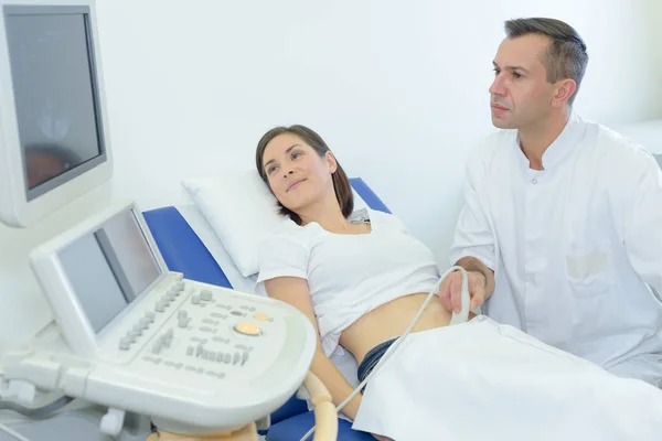 Mujer embarazada mirando la pantalla durante el ultrasonido —  Fotos de Stock
