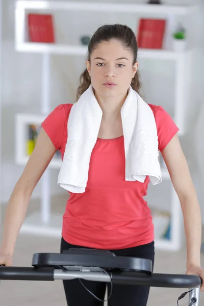 Passa brunett som träna på motionscykel hemma — Stockfoto