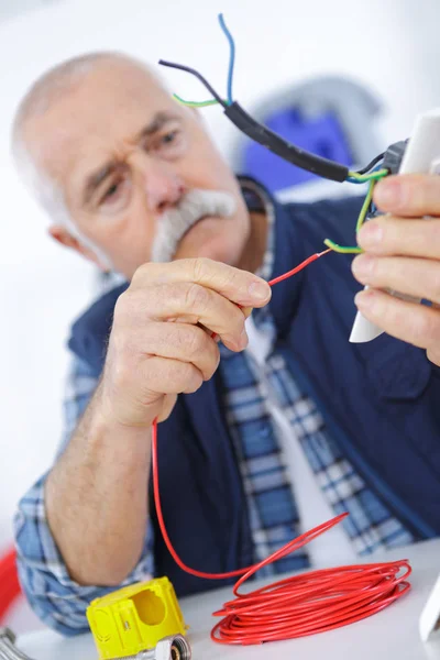 Iş yerinde rahat kıdemli elektrikçi — Stok fotoğraf