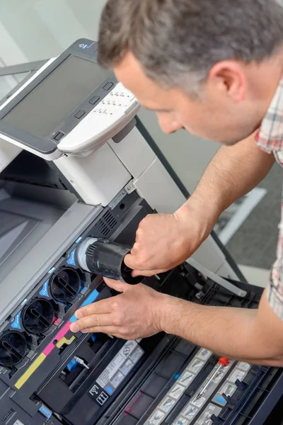 Homem substituindo tinta na impressora — Fotografia de Stock
