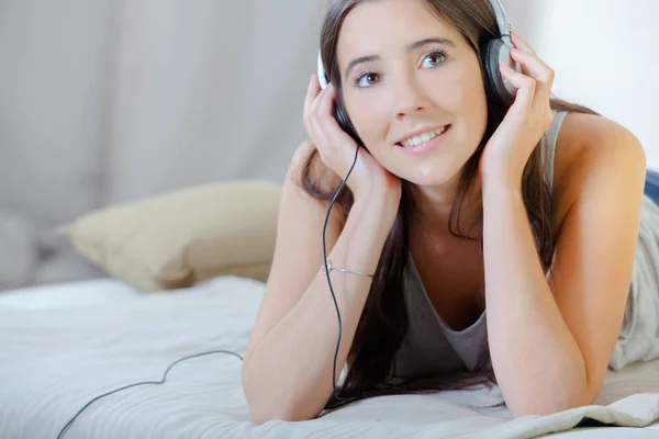 Femme écoutant de la musique au lit — Photo