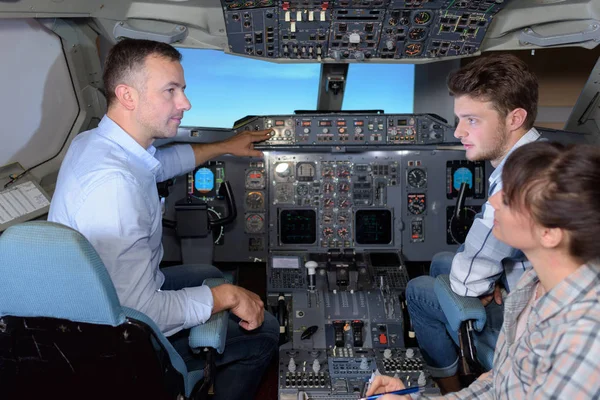 Homem mostrando aos jovens controles de aeronaves — Fotografia de Stock