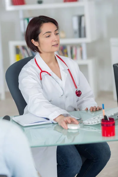 Médico mulher em um escritório moderno sentado na mesa Fotos De Bancos De Imagens