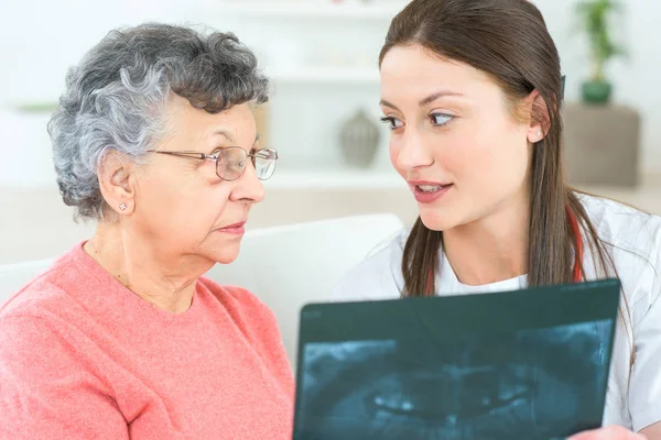 Showing x-ray to elderly patient — Stock Photo, Image
