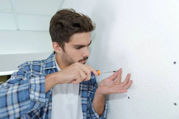 Behörig elektriker förbereder hål innan du installerar apparaten — Stockfoto