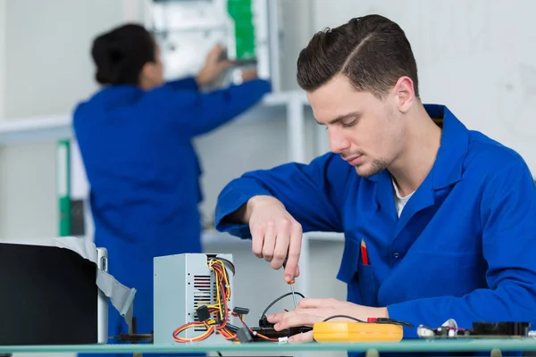 Team av studenter som undersöker och reparerar datordelar — Stockfoto