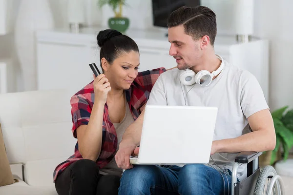 Fogyatékkal élő férfi laptoppal ül a barátnője mellett — Stock Fotó