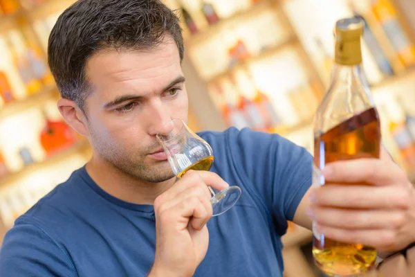 알코올 라벨을 읽는 남자 — 스톡 사진