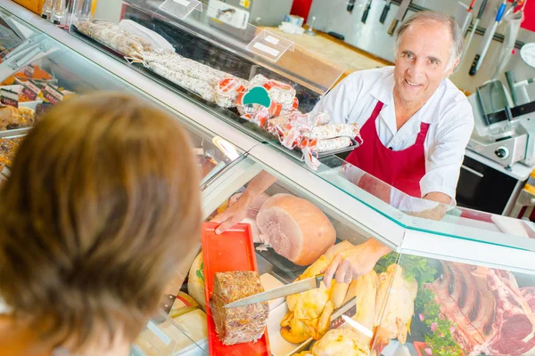 Açougueiro servindo cliente com pate — Fotografia de Stock