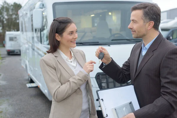 Vendedor passando chaves do motorhome ao cliente — Fotografia de Stock