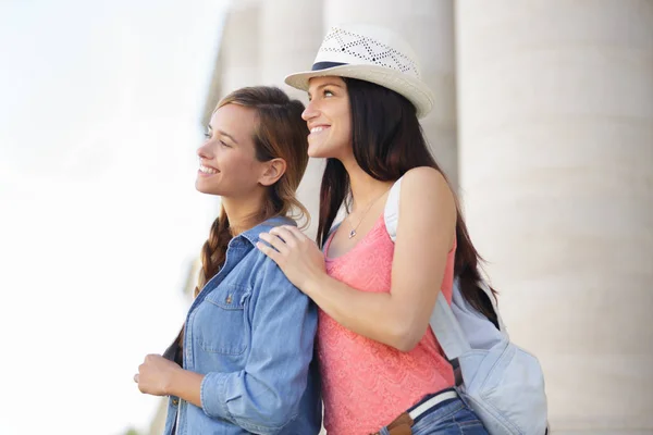 Glückliche Freundinnen spazieren im Urlaub durch die Stadt — Stockfoto