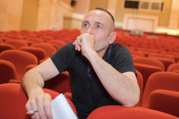 Uomo in teatro vuoto che tiene il quaderno — Foto Stock