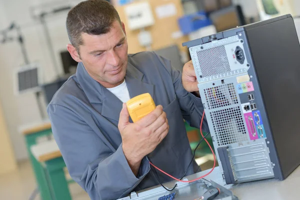 Reparatör testa datorn med multimeter — Stockfoto