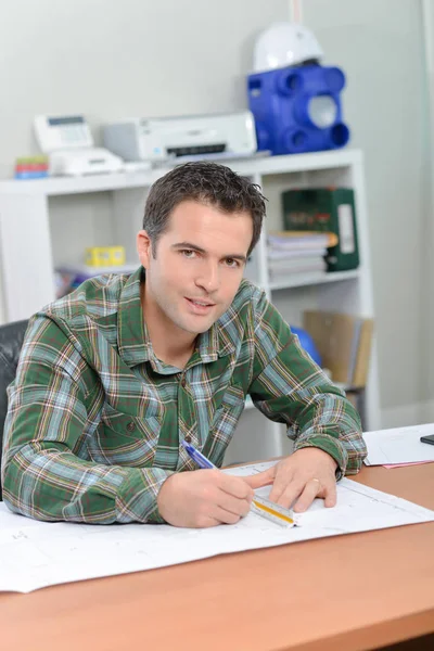 Man zat op Bureau werkt op schaal tekeningen — Stockfoto