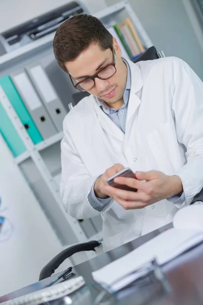 Jonge chemicus type op smartphone in lab — Stockfoto