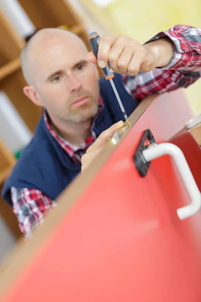 Stående unga manliga snickare reparera dörrlåset — Stockfoto