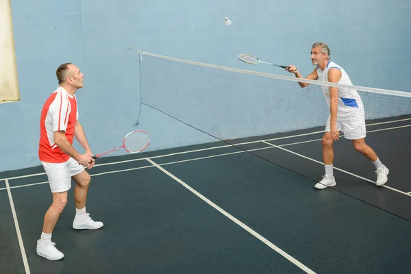 Hombres jugando bádminton y bádminton — Foto de Stock