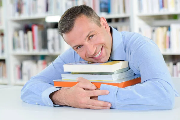 Homem de meia idade segurando livros — Fotografia de Stock