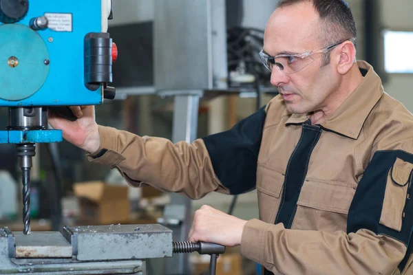 Werknemer met behulp van de bench boor — Stockfoto