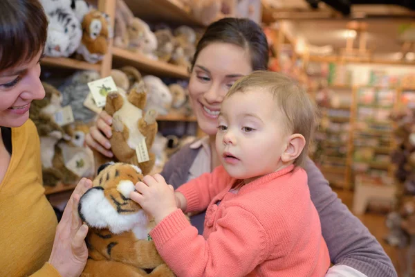 Mère et fille avec vendeur attrayant dans le magasin de jouets — Photo