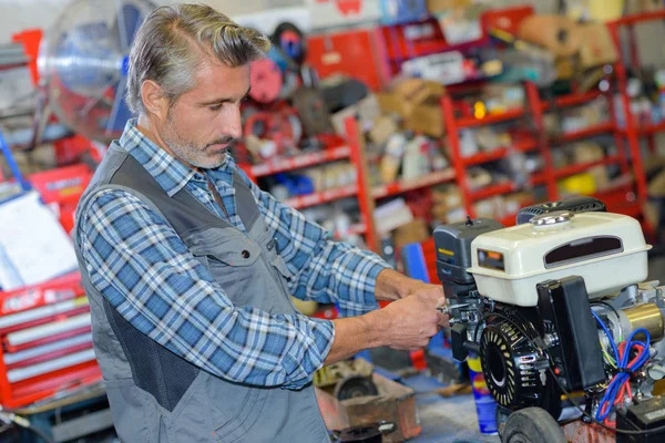 Mechaniker repariert den Motor eines Rasenmähers — Stockfoto