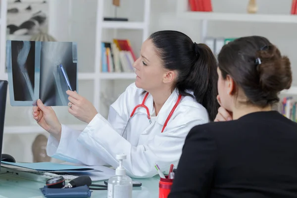 Female doctor showing patients x ray — Stock Photo, Image