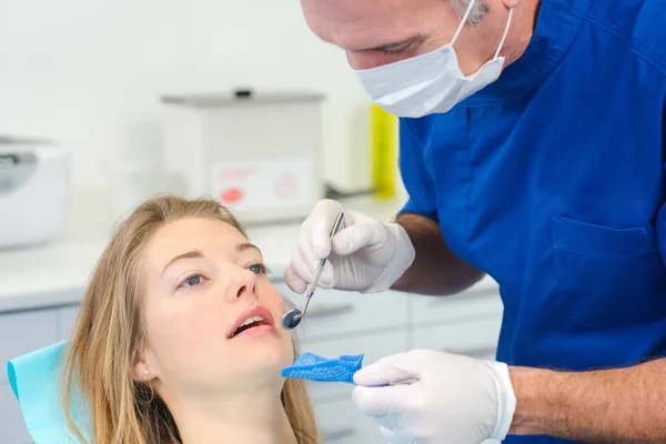 Dentista utilizzando specchio per vedere meglio — Foto Stock