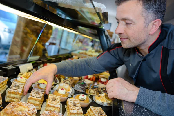 Baker zbiórki ciasto z licznika — Zdjęcie stockowe