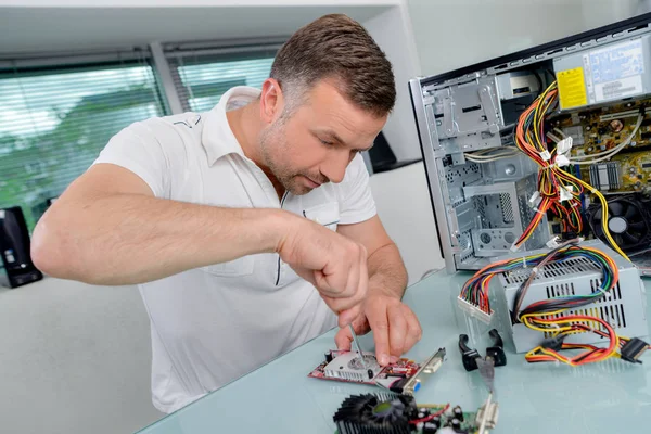 Mężczyzna pracujący na zdemontowane urządzenia elektroniczne — Zdjęcie stockowe