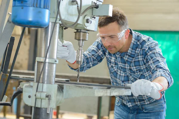 Ο άνθρωπος χρησιμοποιώντας ένα μεταλλικό driller — Φωτογραφία Αρχείου